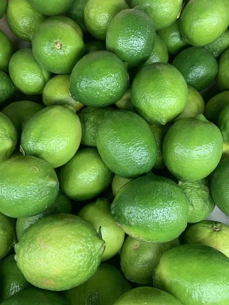 Un sacco di lime verdi maturi per cucinare uno sfondo — Foto Stock