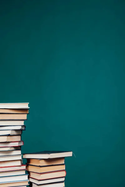 Viele Stapel Lehrbücher für Prüfungen an der Universität in der Bibliothek auf grünem Hintergrund — Stockfoto