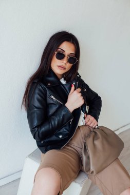 Siyah güneş gözlüklü güzel, modaya uygun esmer bir kadının portresi.