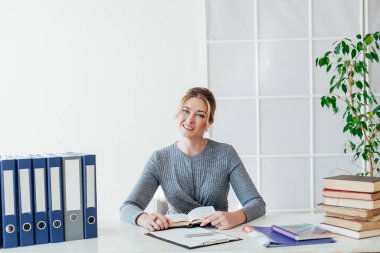 Ofiste kitapları olan güzel bir iş kadını portresi.