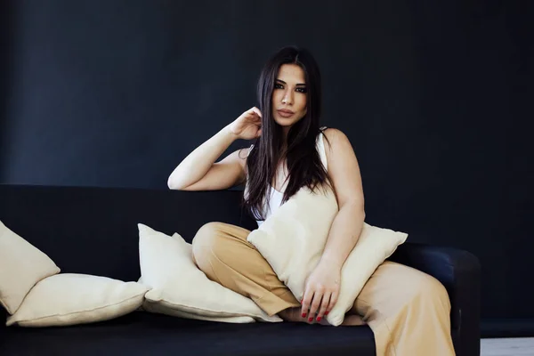 Portrait of a beautiful fashionable oriental woman on the couch in home — Stock Photo, Image