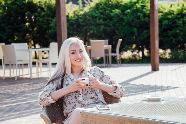 Blonde girl sitting at the beach restaurant coffee — Stock Photo, Image