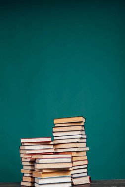 Üniversite sınavları için kütüphanenin yeşil arka planı üzerine bir sürü eğitici kitap
