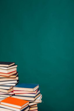 Üniversite sınavları için kütüphanenin yeşil arka planı üzerine bir sürü eğitici kitap