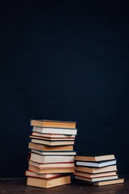 Üniversite sınavları için kütüphanenin siyah arkaplanı üzerine bir sürü eğitici kitap