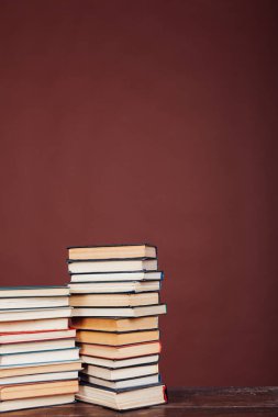 Üniversite sınavları için kütüphanenin kahverengi arkaplanı üzerine bir sürü eğitici kitap