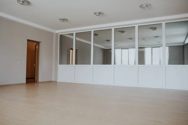 large room with a partition with mirrors