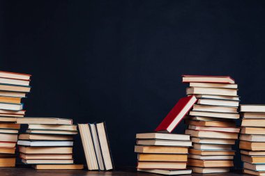 Üniversite sınavları için kütüphanede siyah arkaplan üzerine bir sürü eğitim kitabı var.