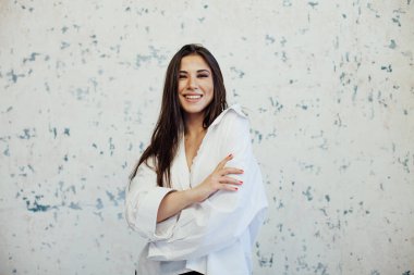 Güzel, modaya uygun, beyaz gömlekli esmer kadın.