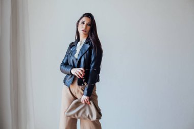 Güzel, modaya uygun, siyah deri ceketli esmer kadın.