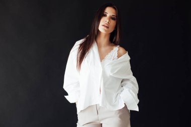 Şortlu ve beyaz gömlekli, doğulu, şık, esmer bir kadının portresi.