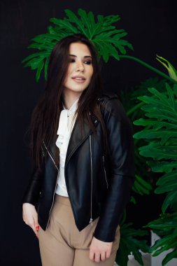 Güzel, modaya uygun, siyah deri ceketli esmer kadın.