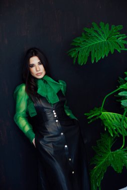 Güzel, modaya uygun, siyah yeşil elbiseli esmer kadın.