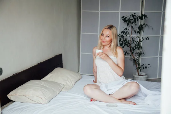 Блондинка на белой постели