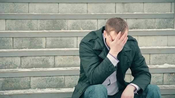 Junger Mann Der Auf Treppe Sitzt Hat Kopfschmerzen — Stockvideo