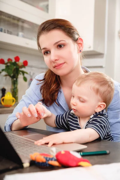 Young mother working with her baby — Stock Photo, Image