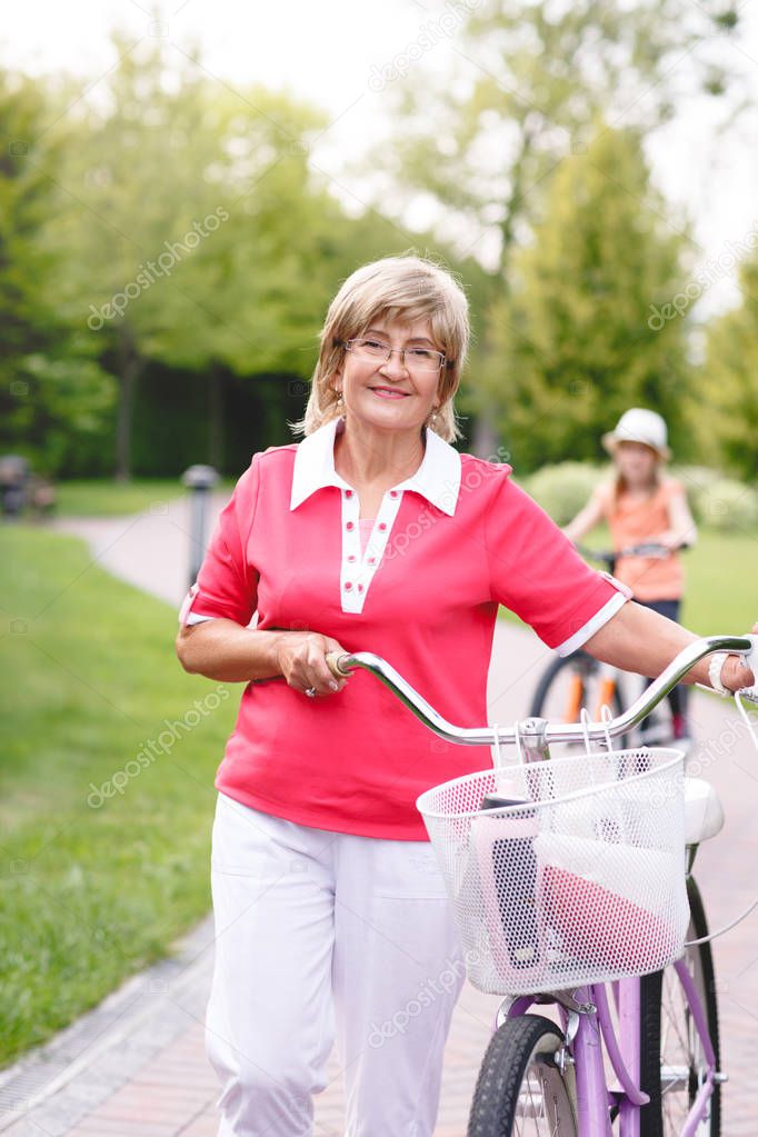 Active senior woman riding bike in a park