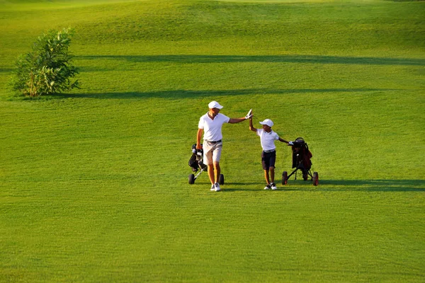 onun oğlu Golf golf sahası üzerinde yürüyen adam
