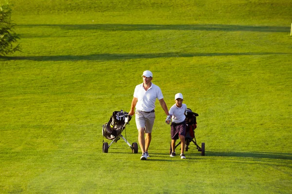 onun oğlu Golf golf sahası üzerinde yürüyen adam