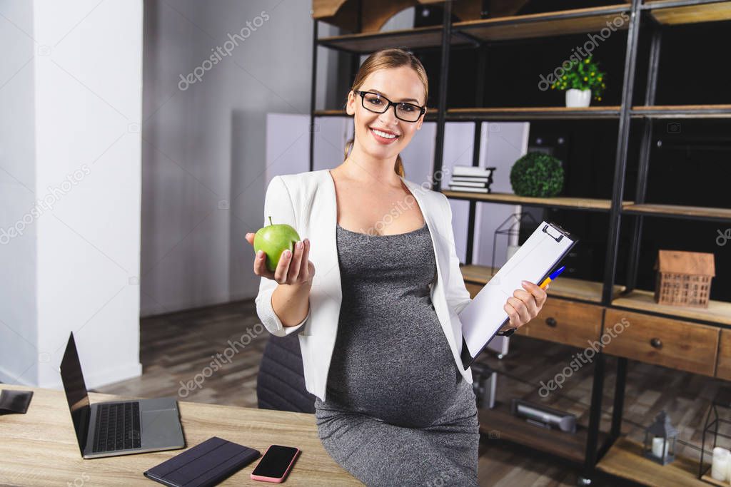 Pregnant mature businesswoman working at office