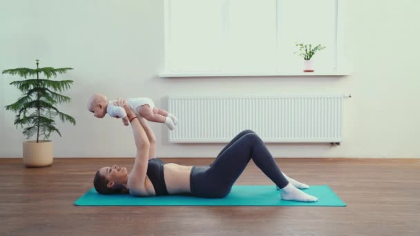 Mãe faz fitness com o bebê em casa — Vídeo de Stock