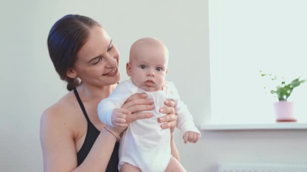 Mom does fitness with the baby at home — ストック動画