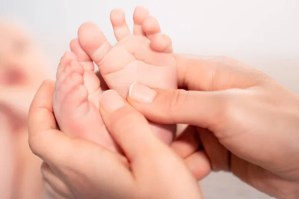 Newborn baby feet on female hands — Stock Photo, Image