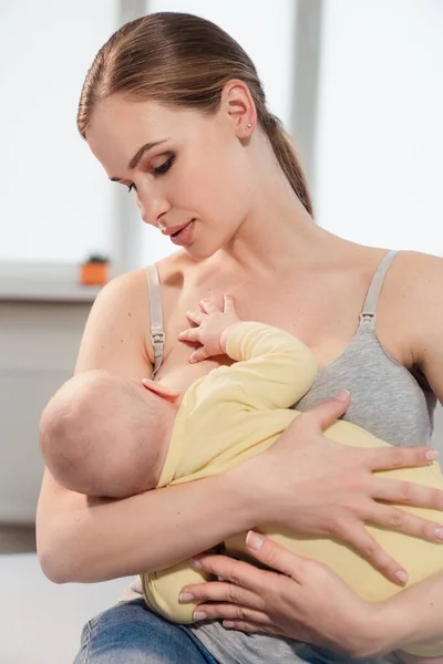 Madre amamantando al bebé en casa. Madre lactante con un niño pequeño —  Fotos de Stock