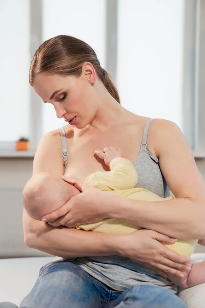 Madre amamantando al bebé en casa. Madre lactante con un niño pequeño —  Fotos de Stock