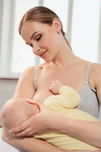 Madre amamantando al bebé en casa. Madre lactante con un niño pequeño —  Fotos de Stock