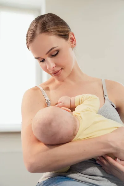 Madre amamantando al bebé en casa. Madre lactante con un niño pequeño —  Fotos de Stock