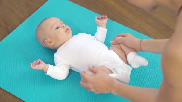 Three month baby boy is receiving massage from mother