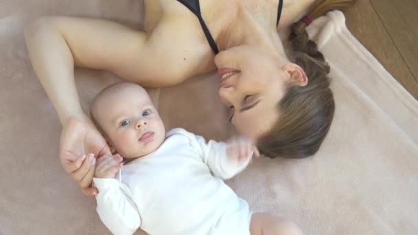 Mother playing with cute baby son on the floor mat — 비디오