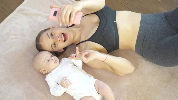 Madre jugando con lindo bebé hijo en la alfombra del piso —  Fotos de Stock