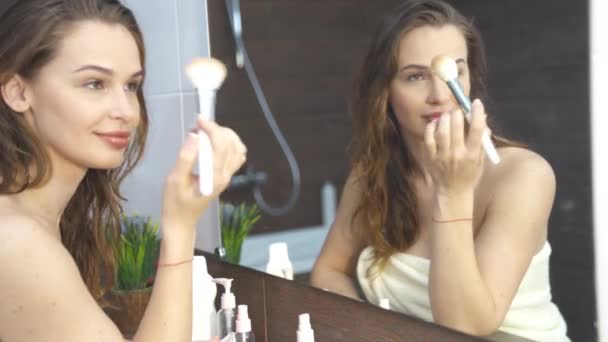Ładna kobieta robi makijaż przed lustrem w łazience — Wideo stockowe