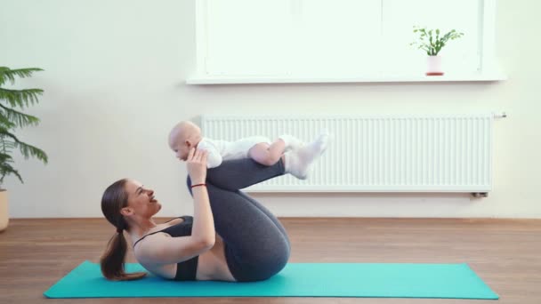 Mãe faz fitness com o bebê em casa — Vídeo de Stock