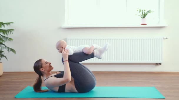 Mamá hace fitness con el bebé en casa — Vídeos de Stock