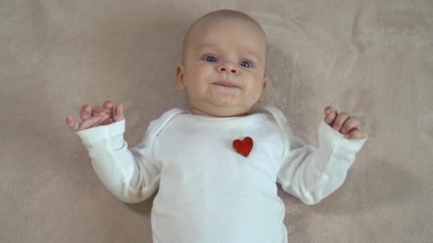 Schattige baby ligt op rug en glimlachen — Stockvideo