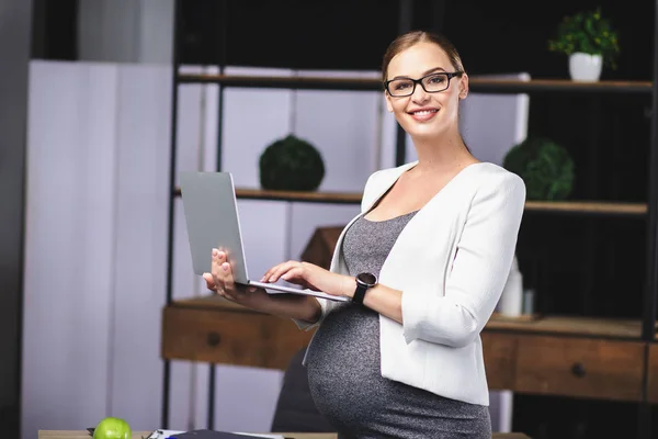 Alegre embarazada está trabajando en la oficina — Foto de Stock