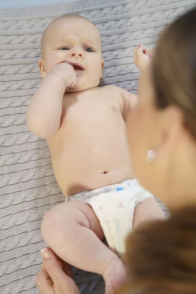 Divertente piccolo bambino che gioca con la mamma su una coperta a maglia — Foto Stock