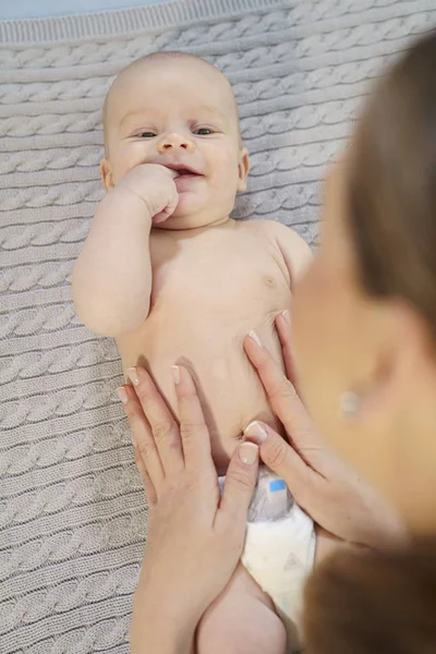 Divertente piccolo bambino che gioca con la mamma su una coperta a maglia — Foto Stock