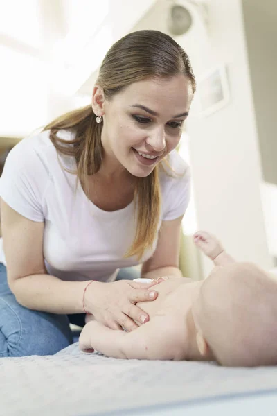 Funny little baby playing with mom on a knitted blanket — Stock Photo, Image