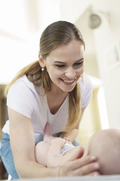 Funny little baby playing with mom on a knitted blanket — Stock Photo, Image