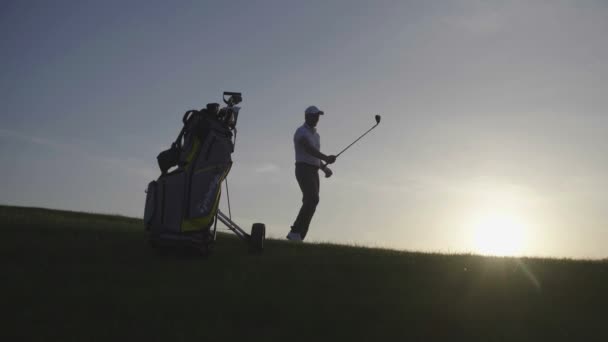 夏の日に完璧なゴルフコースを歩いて彼の息子ゴルファーと幸せな男 — ストック動画