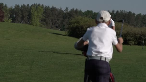Golfista szczęśliwym chłopcem. Wesoły chłopiec na polu golfowym o zachodzie słońca — Wideo stockowe