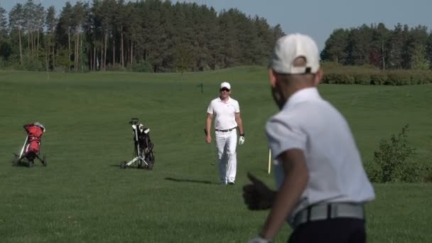 Szczęśliwy człowiek z jego syn golfistów, chodzenie na doskonałe pole golfowe w letni dzień — Wideo stockowe
