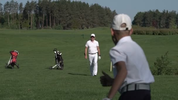 Ευτυχισμένος άνθρωπος με του γιος golfers περπατώντας στο τέλειο γκολφ στη θερινή ημέρα — Αρχείο Βίντεο