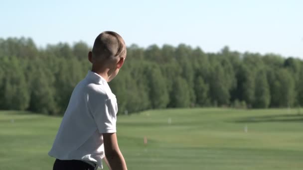 快乐的男孩高尔夫球手。愉快的小辈男孩在高尔夫球场在日落 — 图库视频影像