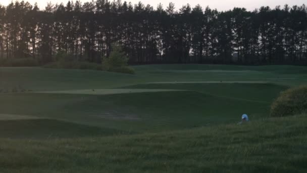 Chico golfista feliz. Niño alegre en el campo de golf al atardecer — Vídeo de stock