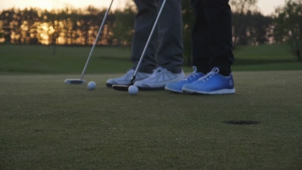 Homme heureux avec son fils golfeurs marchant sur le parcours de golf parfait le jour d'été — Video